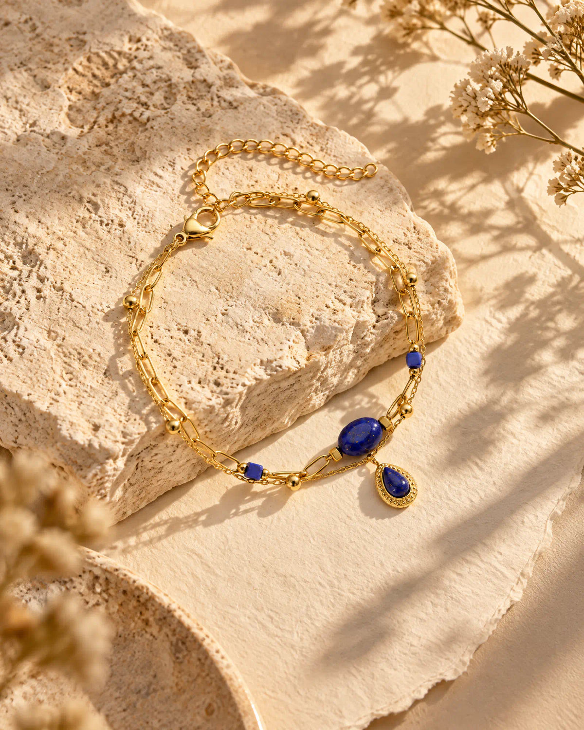 Midnight Teardrop Layered Bracelet resting on natural limestone stone