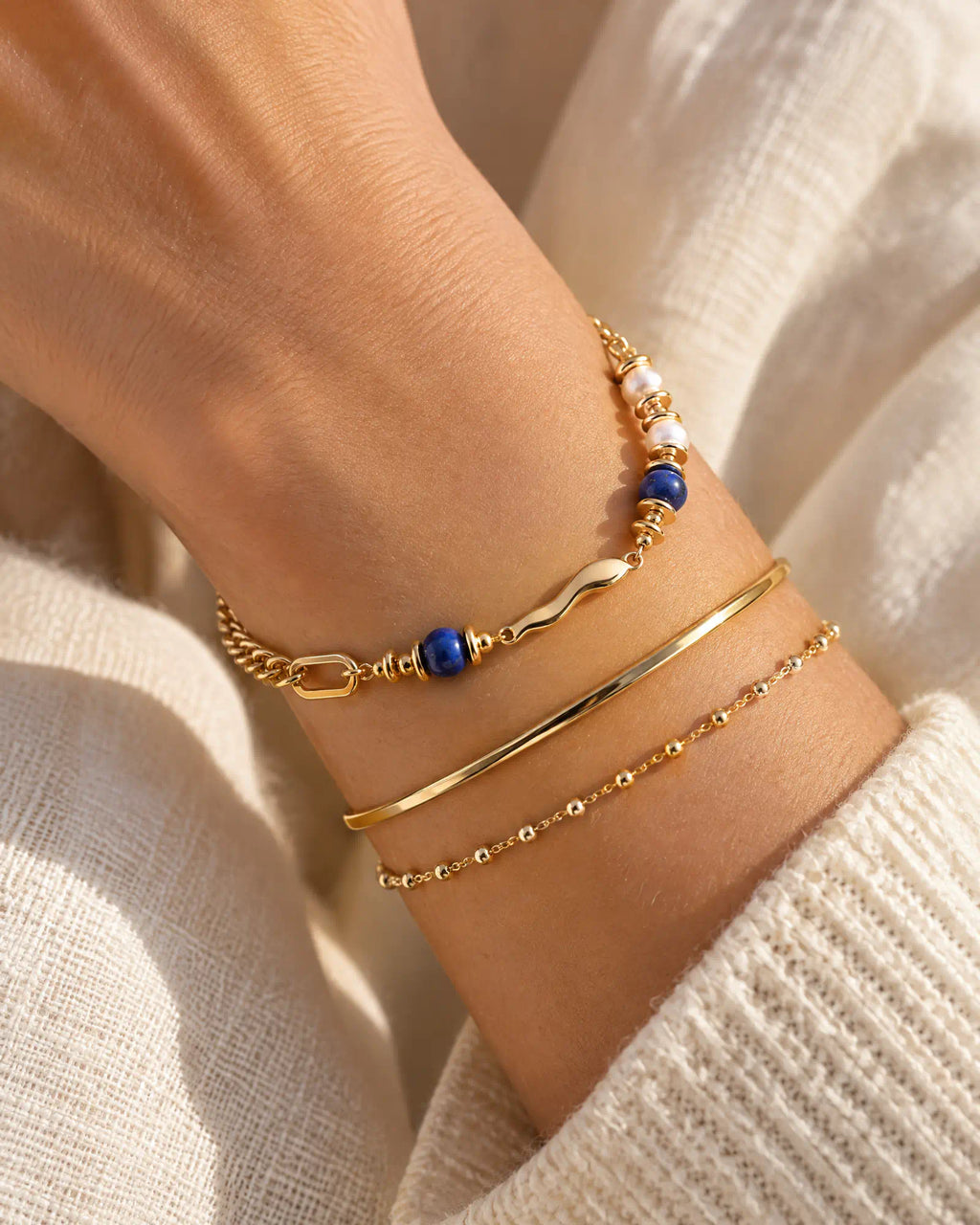 Fluid Wave Asymmetric Bracelet styled in a wrist stack with slim bangles