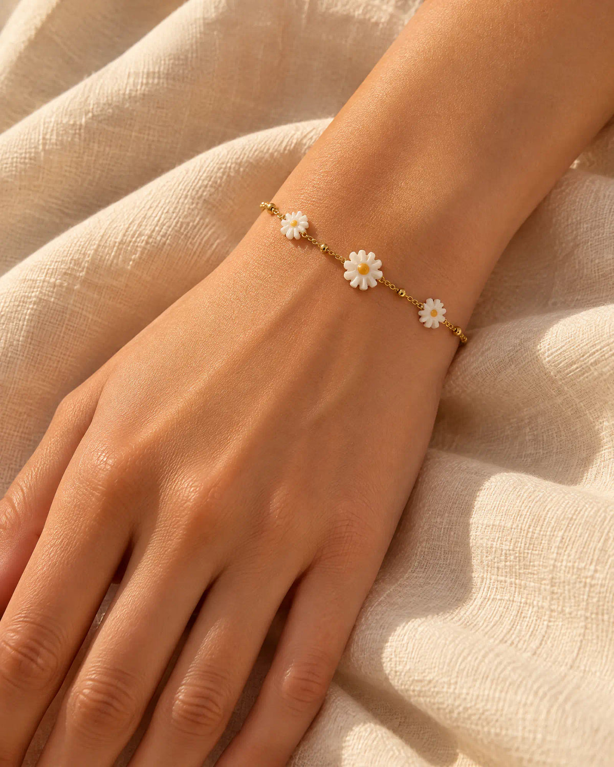 Hand resting gently wearing Sunlit Daisy Station Bracelet