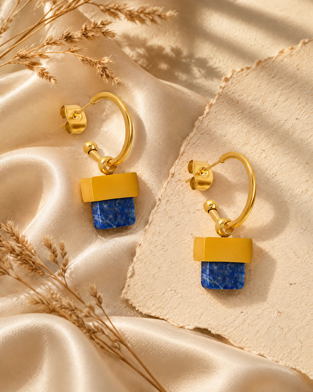 Stepped Horizon Hoop Earrings resting on draped silk fabric