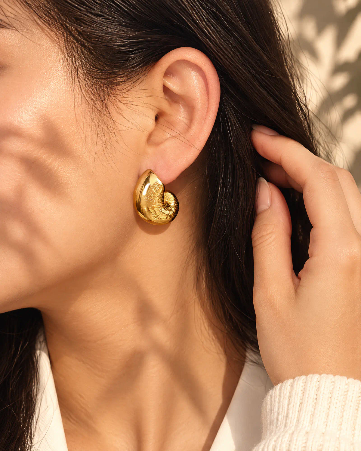 Tucking hair behind ear wearing Coiled Nautilus Shell Stud