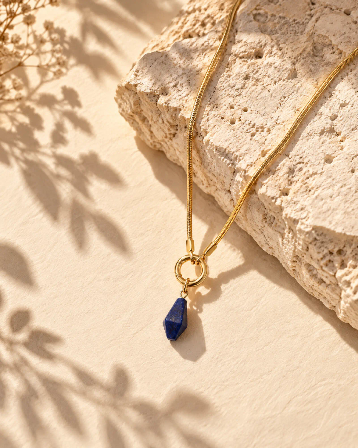 Midnight Faceted Prism Pendant flat lay on textured limestone
