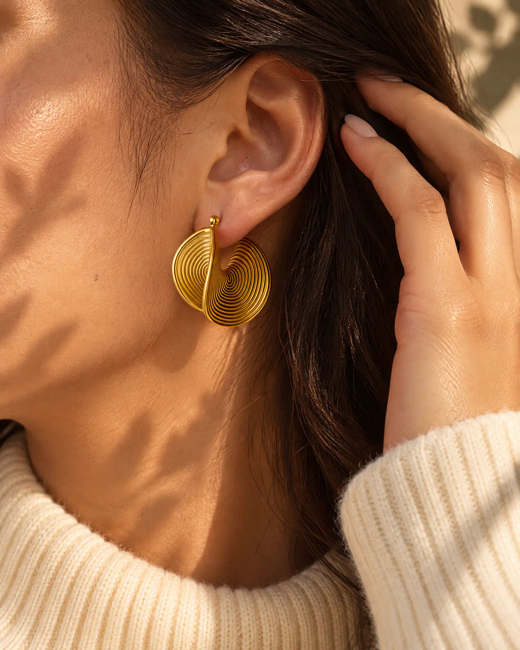Model tucking hair behind ear wearing Spiral Twist Statement Earrings