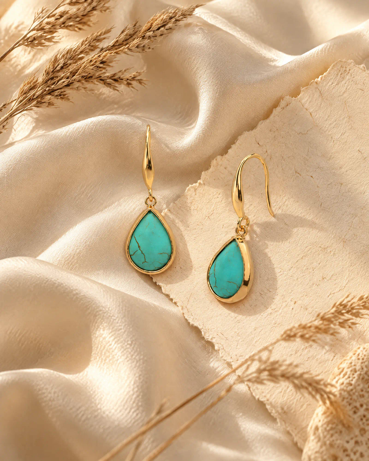 Coastal Teardrop Drop Earrings resting on draped silk fabric