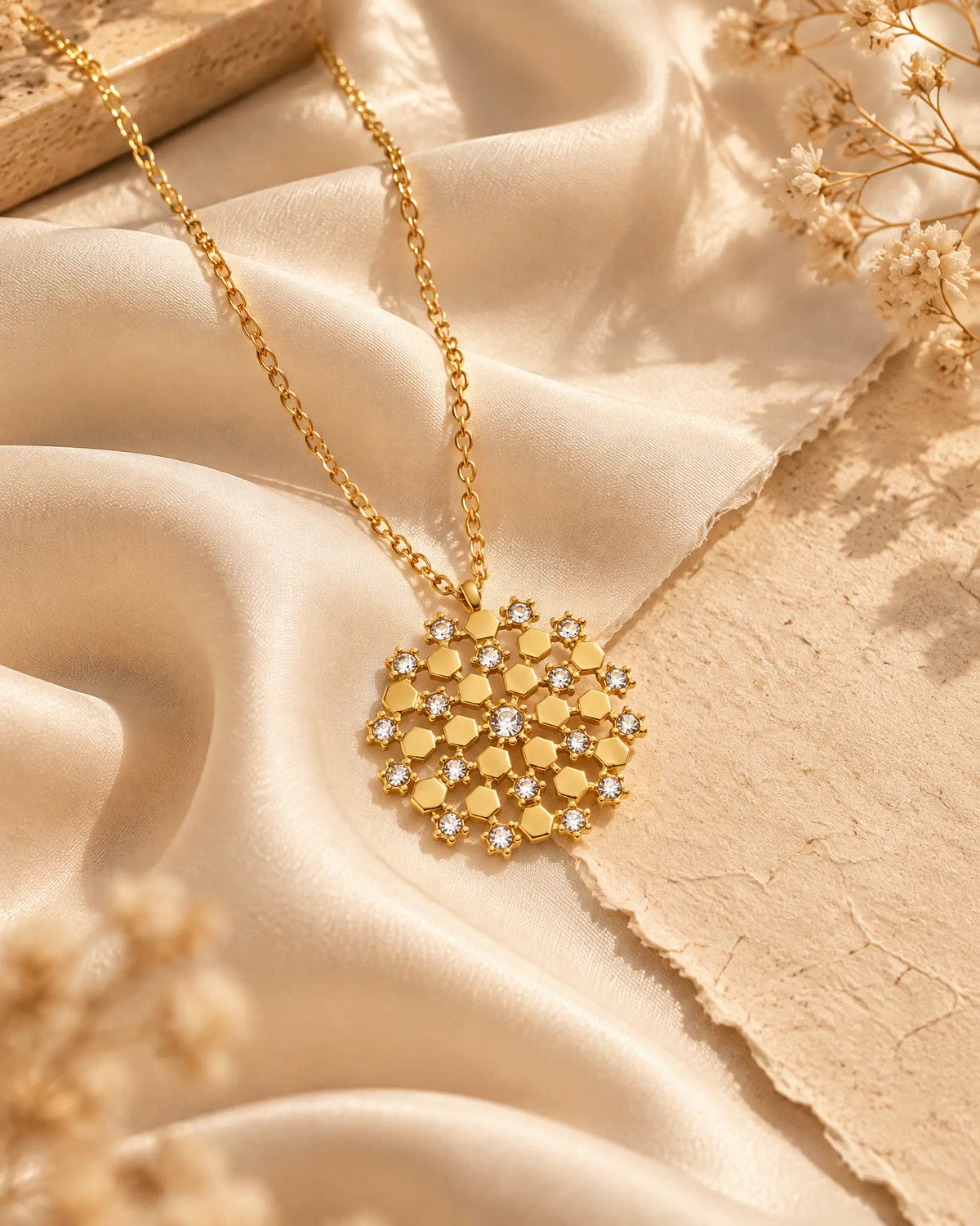 Wearlumi Honeycomb Mosaic Medallion Pendant Necklace draped over champagne silk fabric