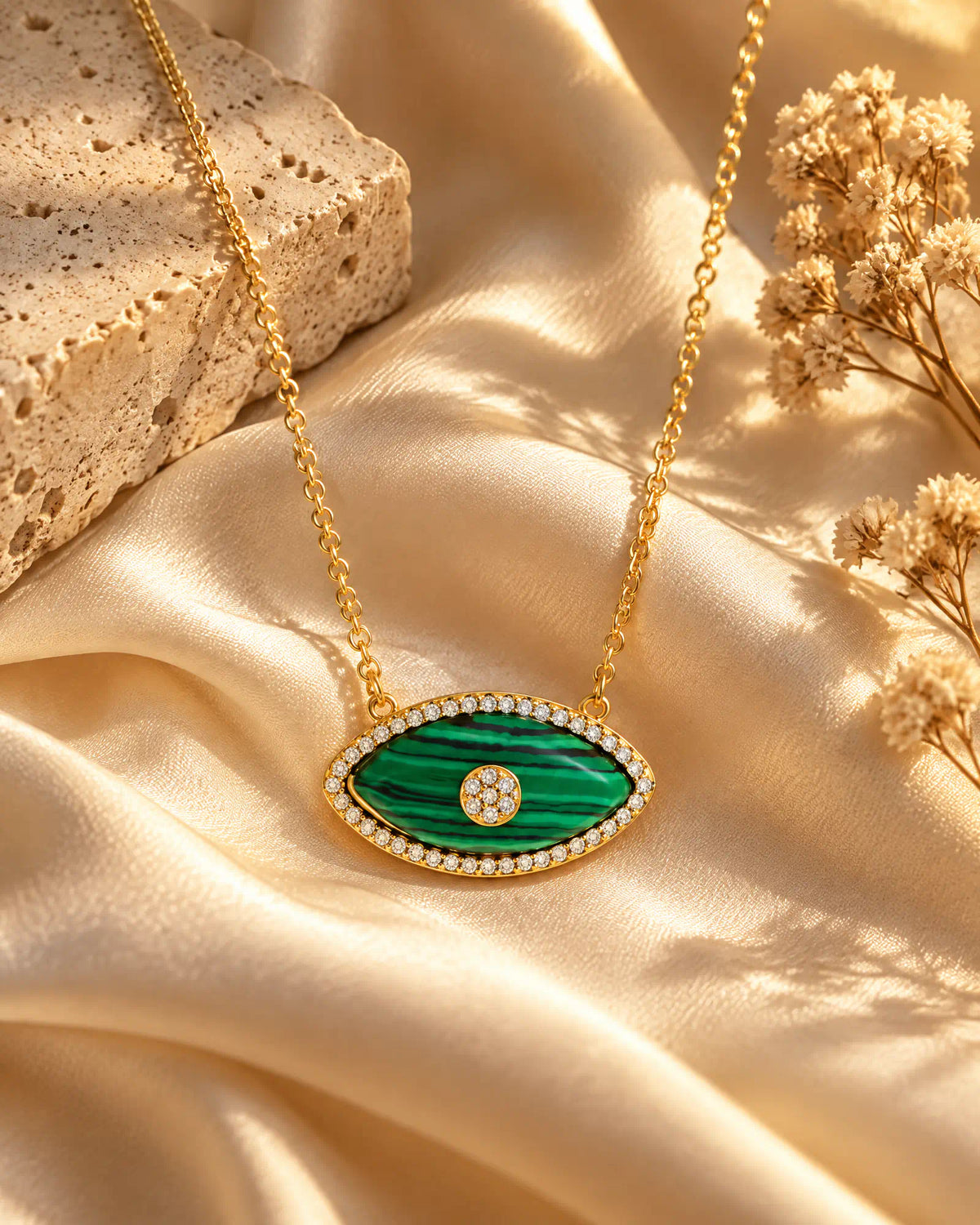 Verdant Eye Pendant draped across cream silk