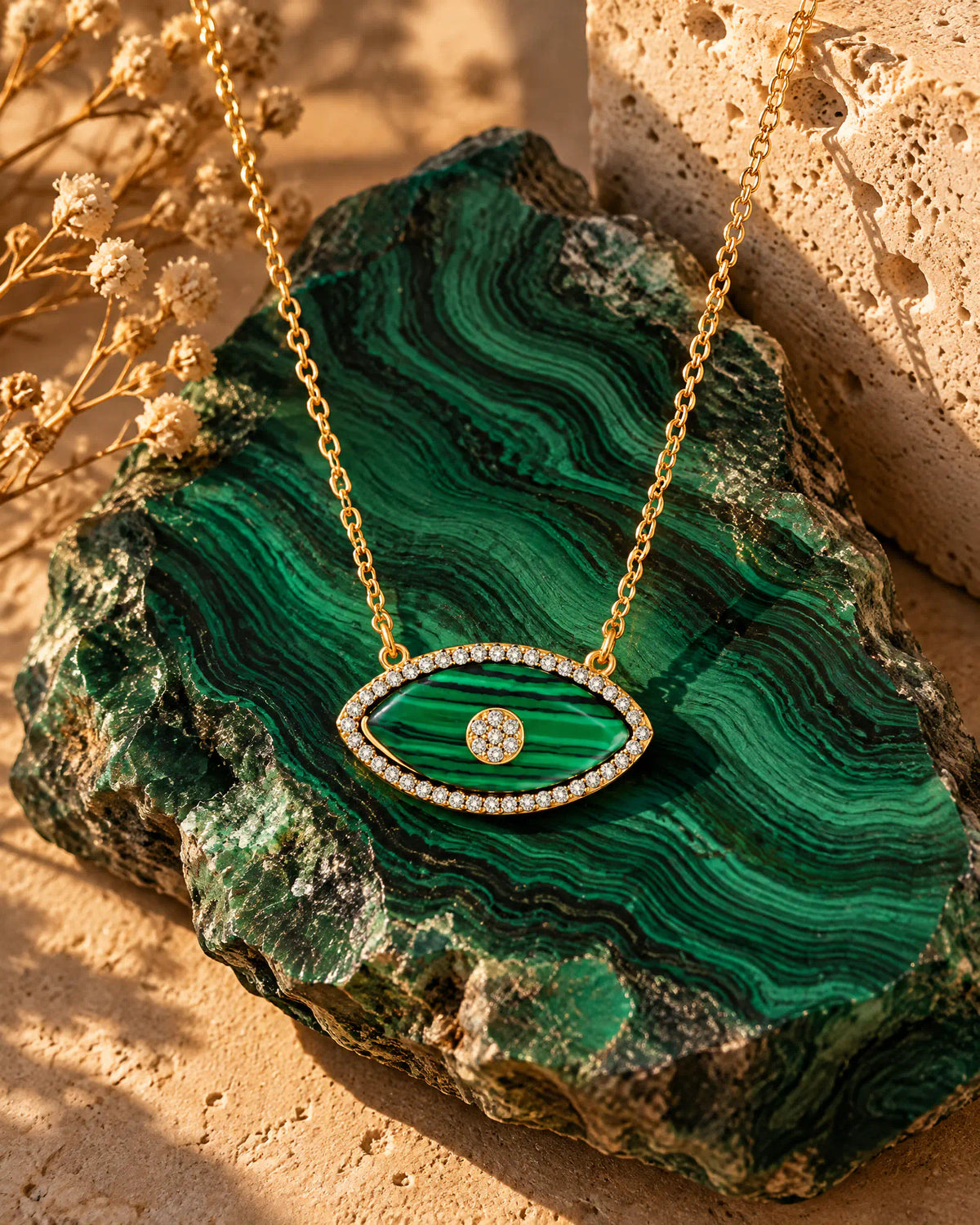 Verdant Eye Pendant resting on a banded green stone slab