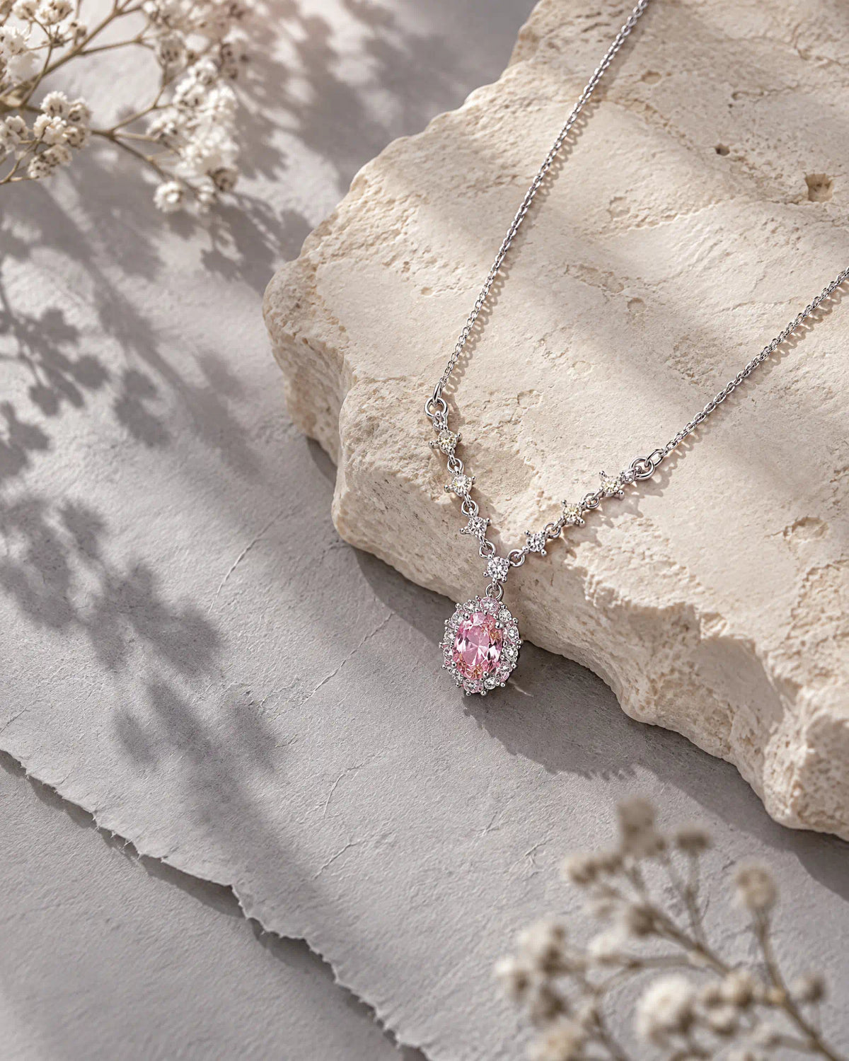 Wearlumi Blush Oval Halo Necklace on warm limestone textured background