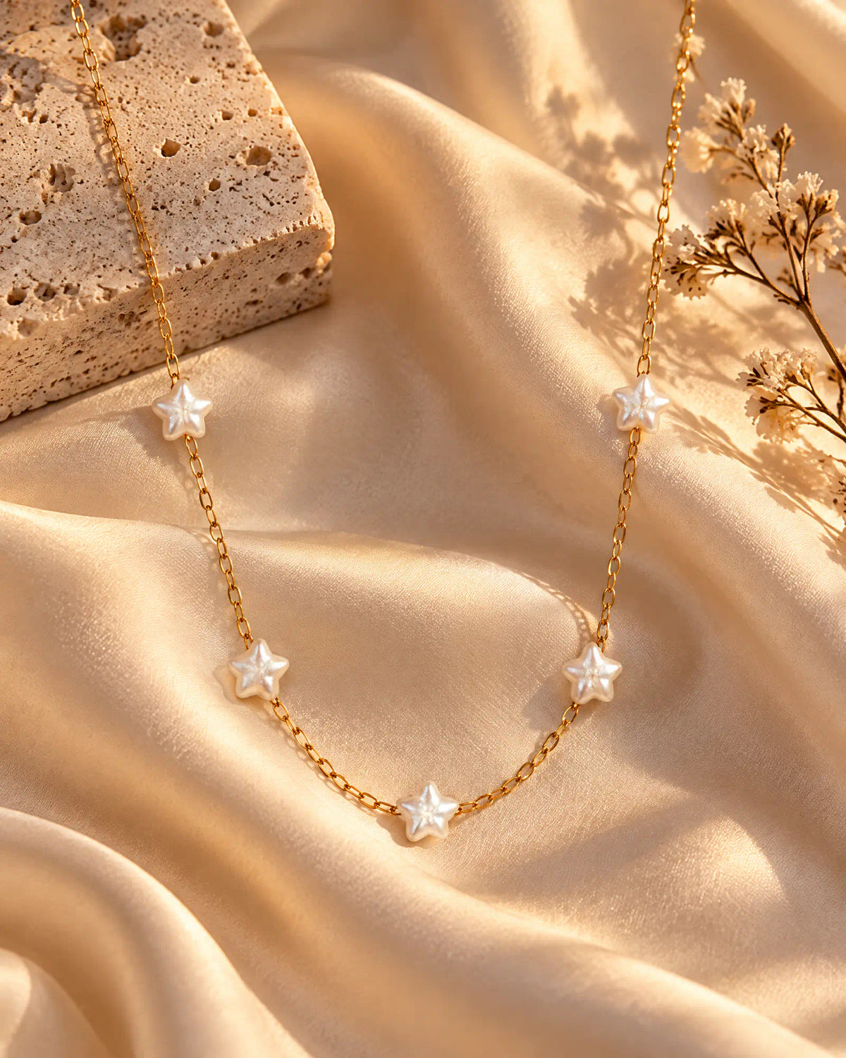 Starlight Station Necklace draped across cream silk