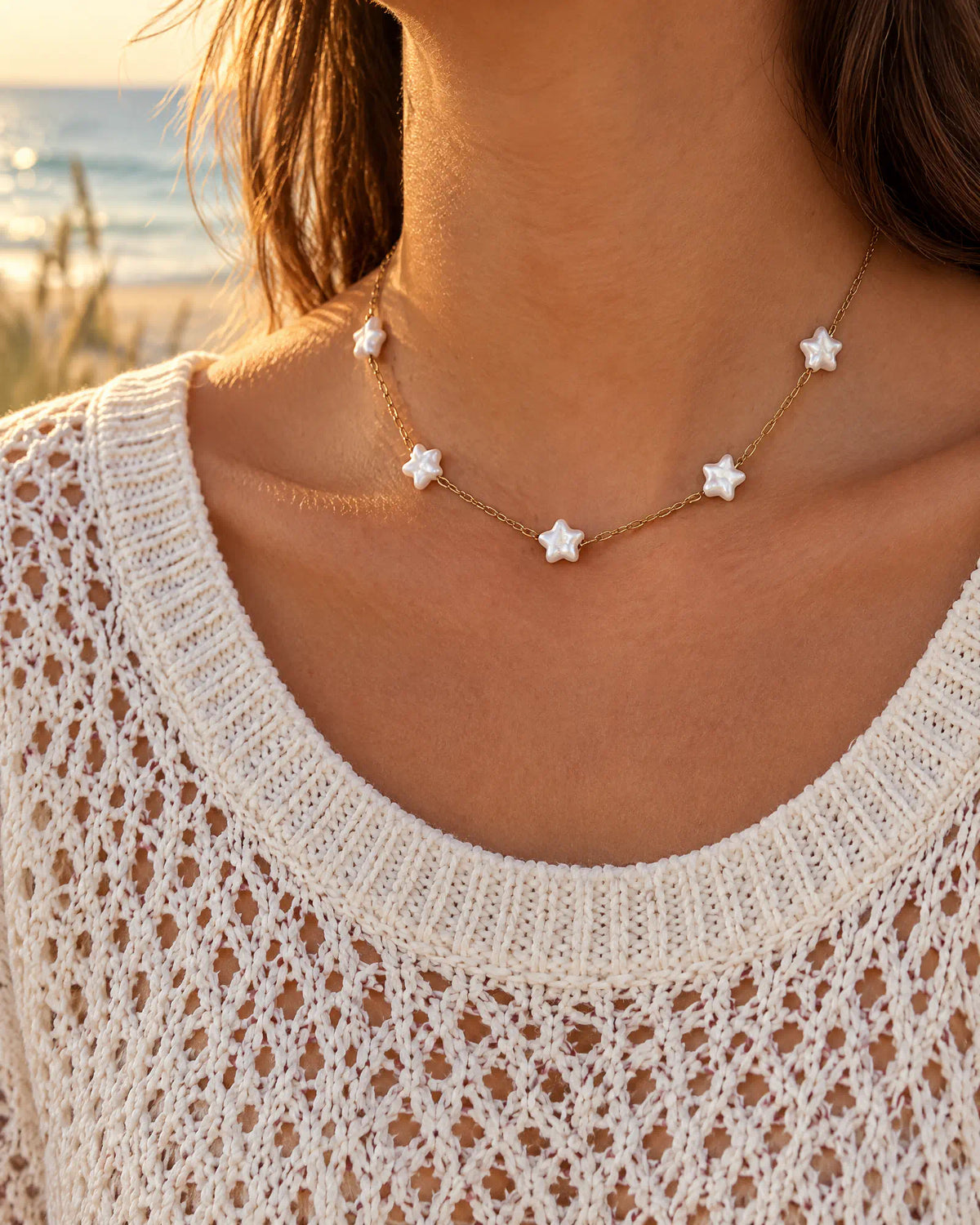Starlight Station Necklace worn with a white crochet top by the sea