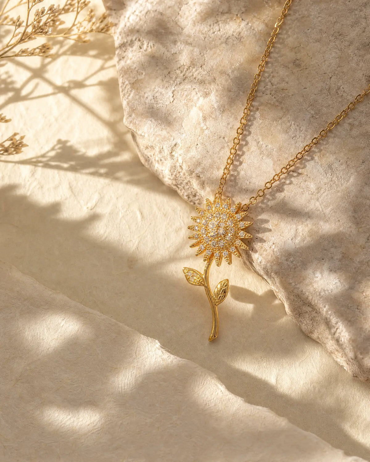 Radiant Sunflower Pendant Necklace resting on limestone