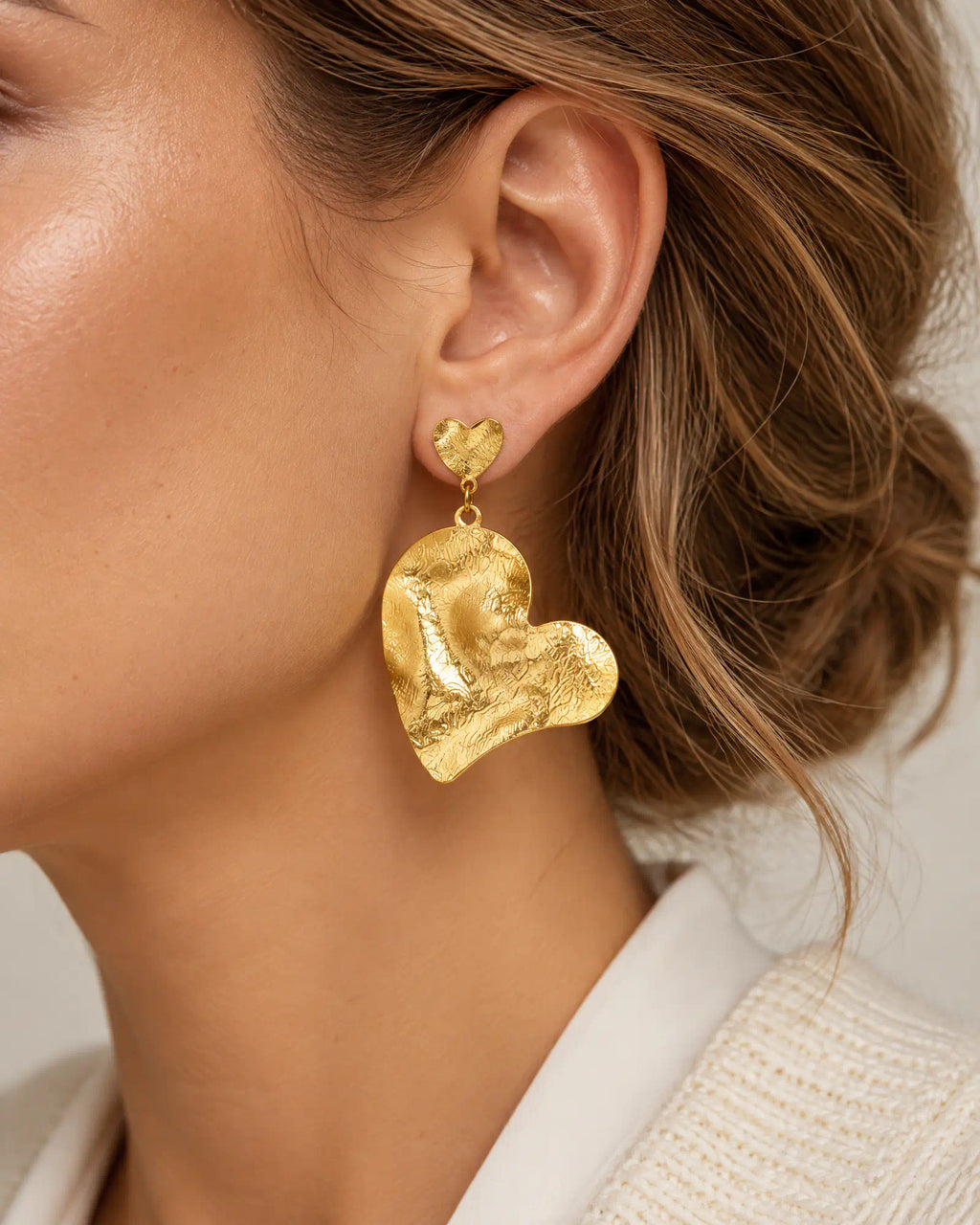 Rippled heart drop earring worn on ear profile